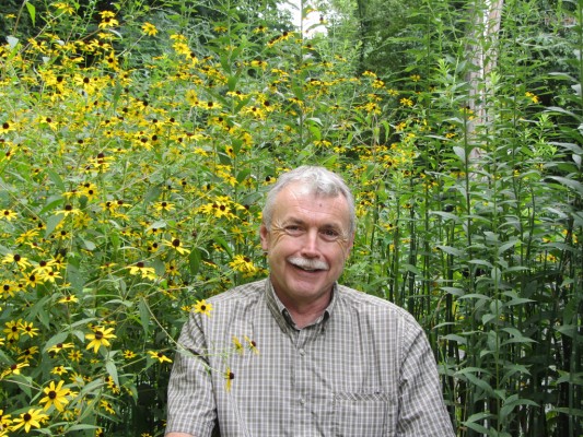 Scott Barnes amidst yellow flowers and horsetail